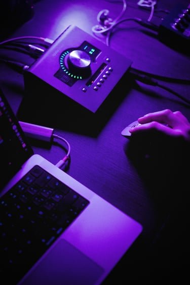 Mano ajustando la interfaz de audio del estudio durante una mezcla