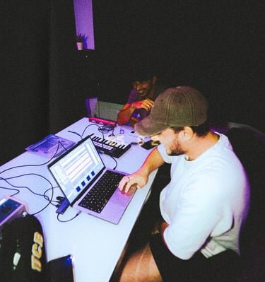 Heeron produciendo en el portátil junto a un artista